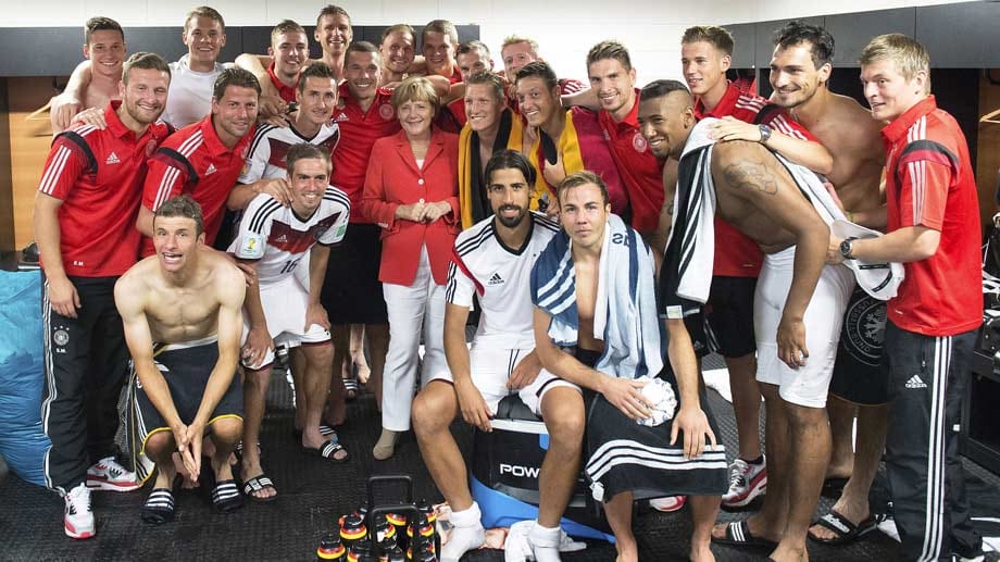 Mannschaftsfoto mit Kanzlerin: Angela Merkel stattet der deutschen Nationalmannschaft nach Spielende einen Besuch in der Kabine ab.
