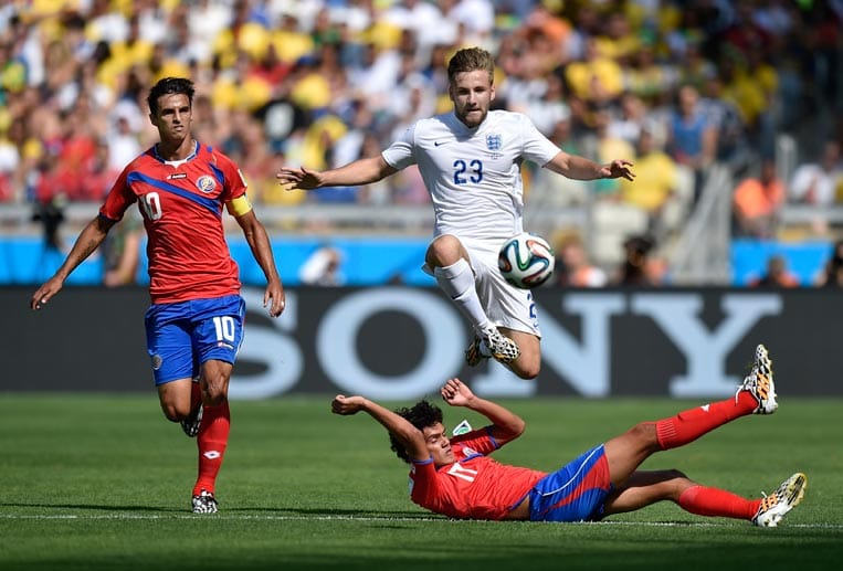 Englands Luke Shaw (re. oben) springt über den Costa Ricaner Michael Barrantes (re. unten). Bryan Ruiz (li.) beobachtet die Szene.