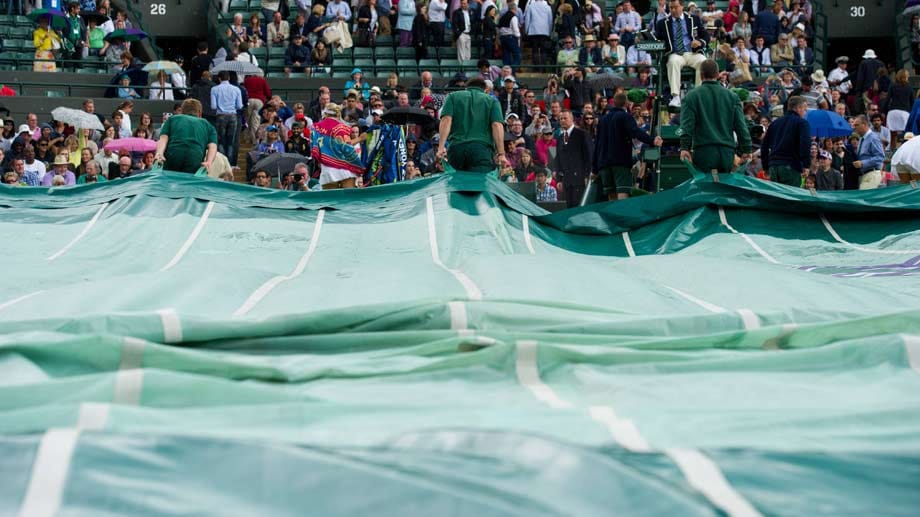Typisch für Wimbledon: Immer wieder muss der "Heilige Rasen" vor Regen geschützt werden. Mitarbeiter bauen dann in Höchstgeschwindigkeit ein Zelt über den Court. Die Zuschauer sind ebenfalls bestens ausgerüstet - mit Schirmen und Capes trotzen sie dem schlechten Wetter.