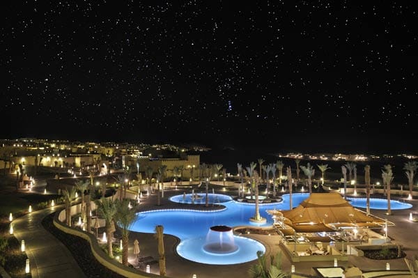 Der beleuchtete Pool des Qasr Al Sarab in Abu Dabhi fällt nachts sofort auf, denn um das Resort ist Wüste, die nachts dunkel und pechschwarz ist. Eine luxuriöse Oase zwischen den Dünen.