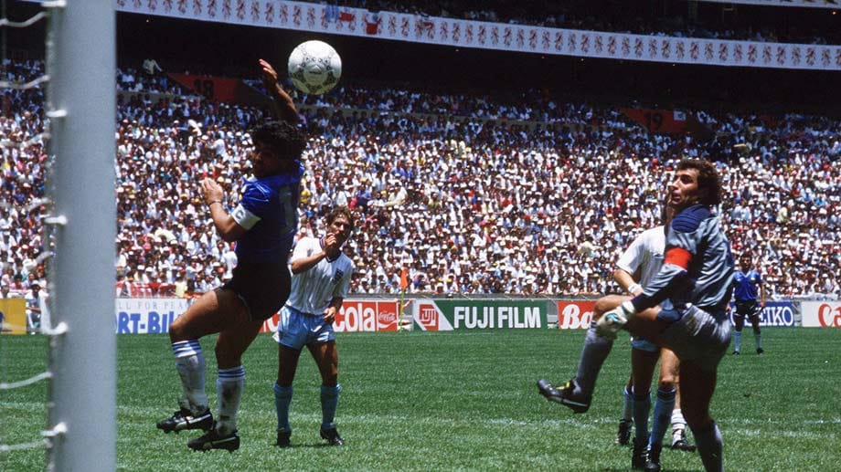 WM 1986 in Mexiko, Viertelfinale Argentinien gegen England. Ein Klärungsversuch (51. Minute) misslingt, Torhüter Peter Shilton kommt aus dem Tor und will den Ball fangen. Auch Diego Maradona, 20 Zentimeter kleiner als Shilton, springt hoch, der Ball fliegt ins Tor. Den körperlichen Nachteil macht er wett, indem er die linke Hand benutzt. "Es war ein bisschen die Hand Gottes und ein bisschen mein Kopf", sagt Maradona. Erst 2005 gibt er zu, den Ball nur mit der Hand gespielt zu haben.