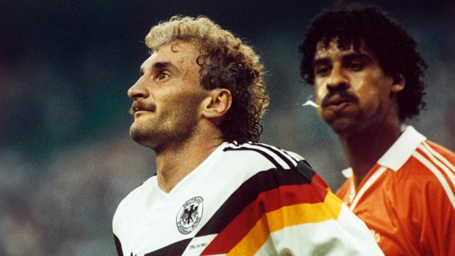 WM 1990 in Italien, Achtelfinale Deutschland gegen die Niederlande: Schon nach gut 20 Minuten rastet Oranje-Star Frank Rijkaard (re.) aus, spuckt Deutschlands Stürmer Rudi Völler in die Locken und zieht ihm wenig später am Ohr. Schiedsrichter Juan Loustau (Argentinien) zeigt Rijkaard die Rote Karte - aber auch Völler. Beim Verlassen des Platzes bespuckt der Niederländer "Tante Käthe" erneut.