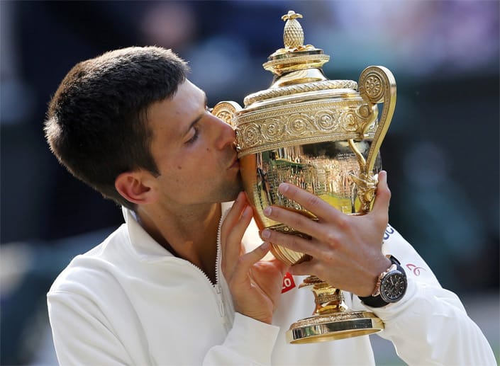 Küsschen für den Pokal: Im Finale ringt Djokovic seinen Kontrahenten Federer in einem Fünfsatz-Krimi nieder und darf die Trophäe in den Londoner Abendhimmel heben.