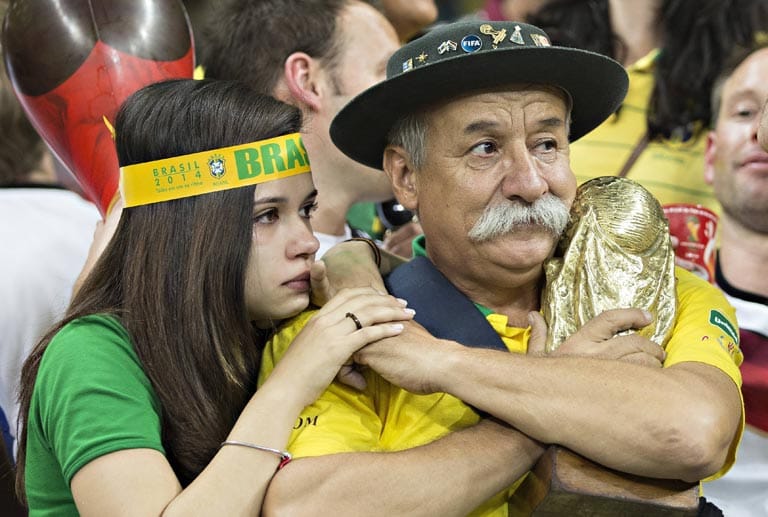 Ein Bild, das um die Welt ging: Clovis Fernandes, Brasiliens bekanntester Fan, klammert sich nach der 1:7-Schmach im Halbfinale gegen Deutschland an den WM-Pokal. Später schenkt er ihn einem deutschen Mädchen