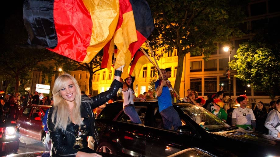 Nach dem Abpfiff ging es auf die Straße: Berlin feiert den Triumph über Argentinien in einem Auto-Korso. Diesen Spaß ließ sich Sängerin Annemarie Eilfeld (li.) nicht nehmen.