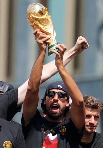 Sami Khedira stemmt den WM-Pokal in den Berliner Himmel.