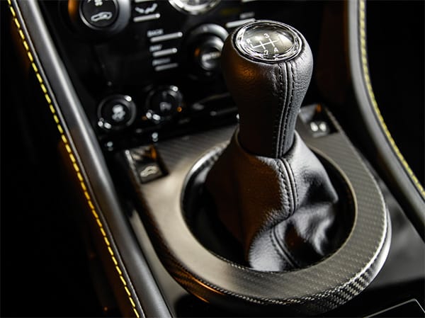 Von Carbon eingefasst glänzt die knackige 6-Gang-Handschaltung mit kurzen Schaltwegen. Nur die Kupplung braucht etwas Eingewöhnung und Übung. Aber lobenswert, dass Aston Martin überhaupt die Wahl lässt.