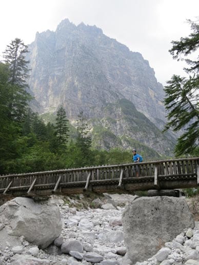 Eine Holzbrücke führt über einen Steinhang.