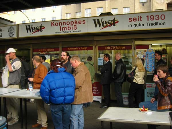 Konnopke ist eine echte Institution und seit 1930 im Familienbesitz. Der Imbiss hat 1960 als erster in Ostberlin Currywürste angeboten. Da es in der DDR wenig Därme gab, wurde die Wurstmasse direkt in heißes Wasser gespritzt und so in Form gebracht.