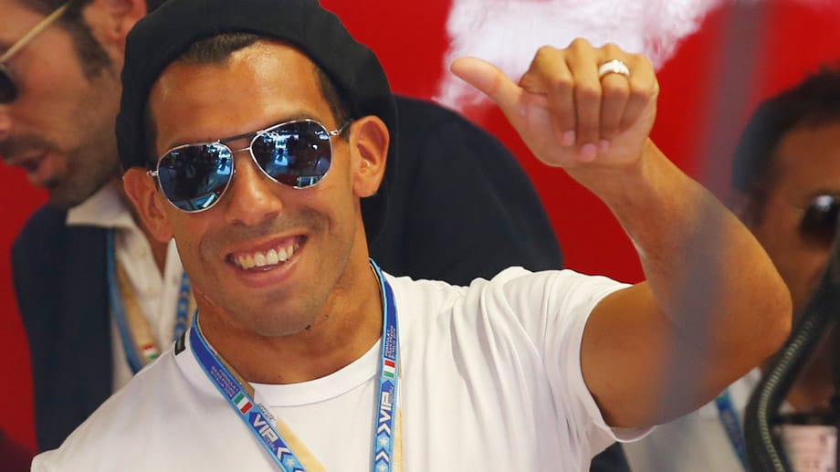Der argentinische Fußball-Profi Carlos Tevez besucht den Formel-1-Zirkus und hat sichtlich Spaß.