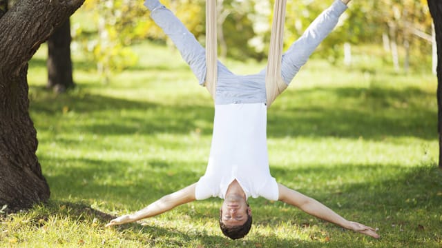 Beim Anti-Gravity-Yoga absolvieren Sie die meisten Übungen in der Luft an einem speziellen Tuch hängend