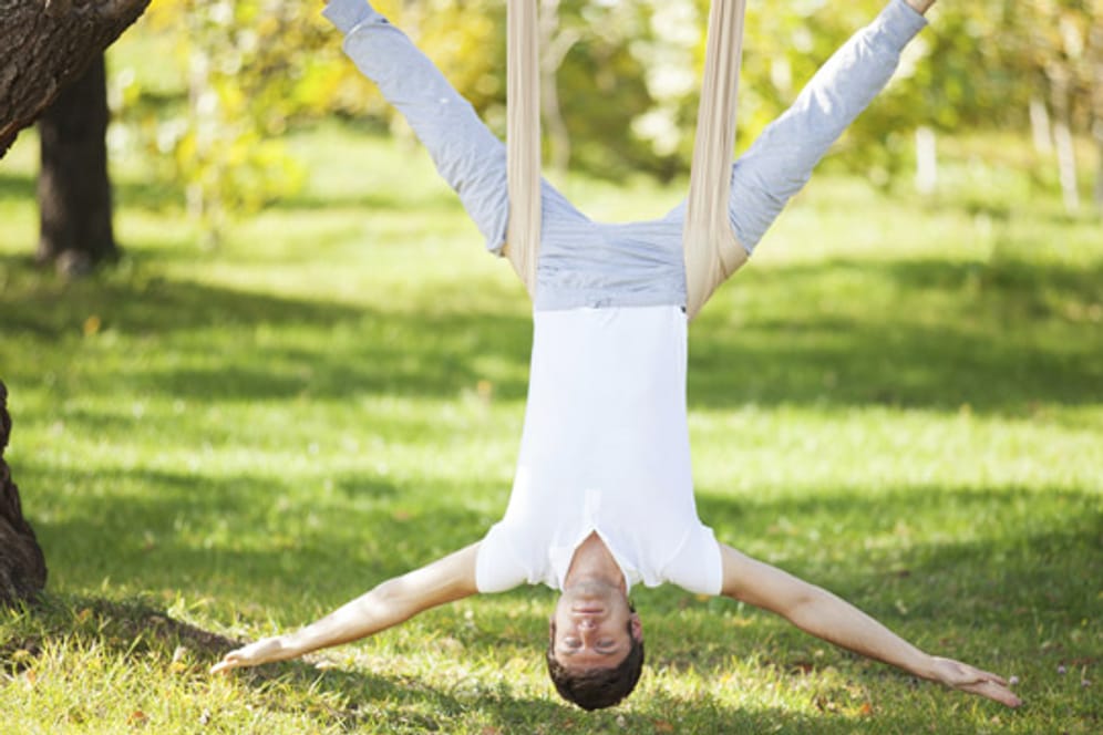 Beim Anti-Gravity-Yoga absolvieren Sie die meisten Übungen in der Luft an einem speziellen Tuch hängend