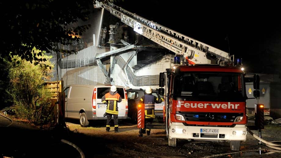 Die Feuerwehr muss zunächst in sicherer Entfernung mit Drehleitern löschen, weil die Hitzeentwicklung extrem stark ist. Die Feuerwehr muss zunächst in sicherer Entfernung mit Drehleitern löschen, weil die Hitzeentwicklung extrem stark ist.