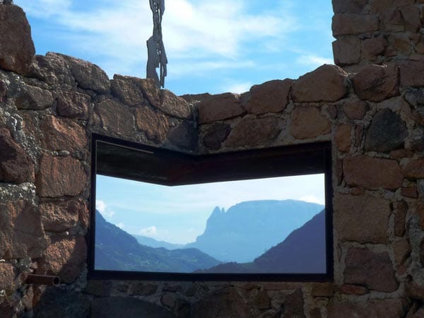 Wer mit Reinhold Messner durch Firmian, wo eines der Museen steht, schlendert, der lernt den Museumsmacher nicht nur als Geschichtenerzähler kennen, er erfährt auch viel über die Hintergründe der Inszenierungen. Die alte Gondel steht nicht von ungefähr vor einem rechteckigen Durchblick auf den Schlern. "Ich nenne das den Postkartenblick", erklärt Messner, "so sehen die meisten heute die Berge - als wohlfeiles Bildmotiv."
