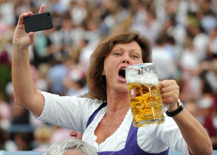 Die bayerische Wirtschaftsministerin Ilse Aigner (CSU) fotografiert sich mit ihrem Handy, als sie am Eröffnungstag des Oktoberfestes ihren Bierkrug in die Höhe hält.