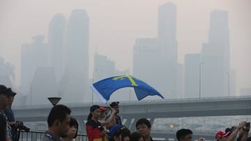 Im Smog von Singapur strömen die Formel-1-Fans zu der Strecke.