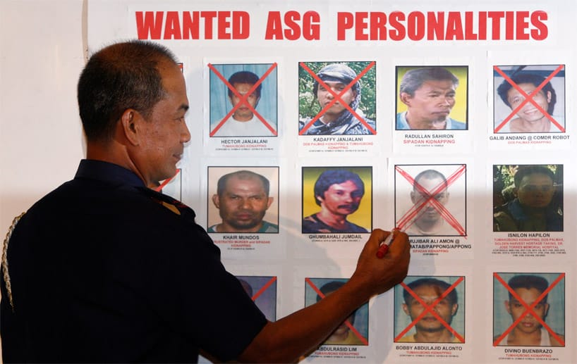 Der philippinische Polizeichef Jesus Verzosa vor einem Fahndungsplakat mit Abu-Sayyaf-Mitgliedern.
