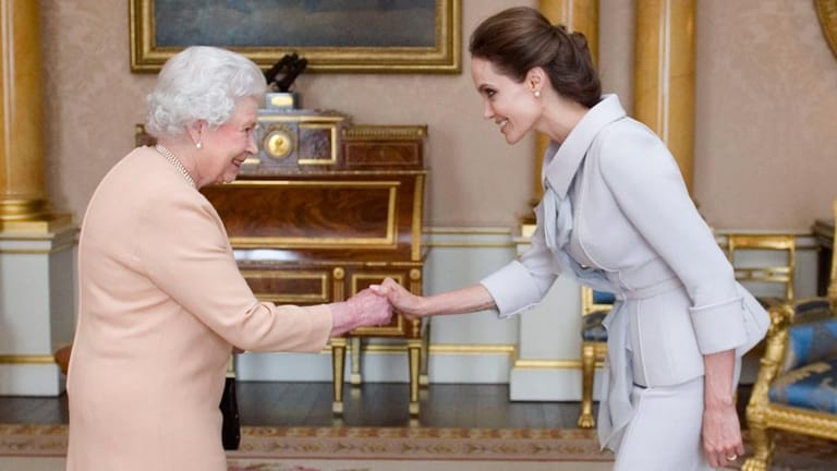 Den Hofknicks beherrscht sie: Angelina Jolie wurde von Königin Elizabeth II. mit dem Titel der "Dame ehrenhalber" ausgezeichnet und damit für ihren Kampf gegen sexuelle Gewalt in Kriegsgebieten geehrt.