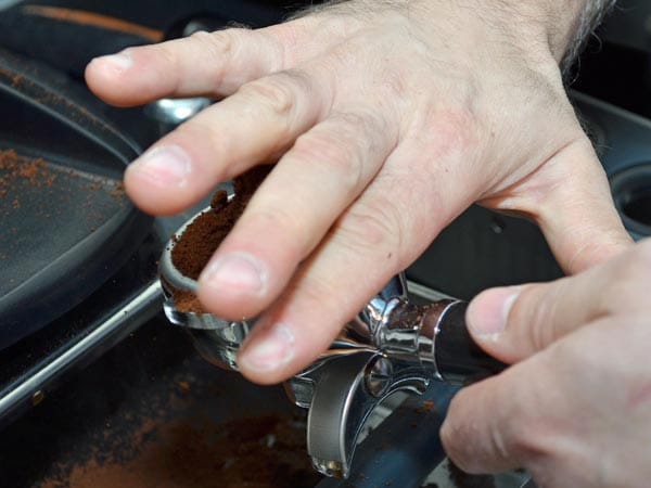 Barista Halil Ege streift das frisch gemahlene Kaffeepulver genau am Rand des Siebträgers ab. Zu viel davon verändert den Geschmack.