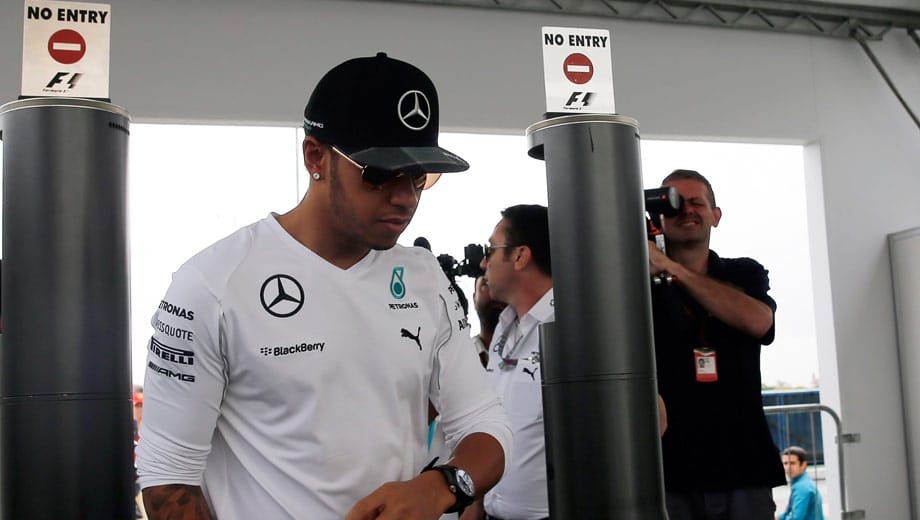 Mit Lewis Hamilton betritt der WM-Führende am Rennsonntag das Fahrerlager.