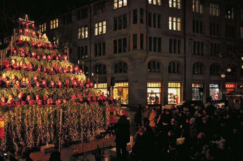 Leuchten können die meisten Weihnachtsbäume. Aber singen? Dieses Kunststück bringt der Singing Christmas Tree von Zürich zustande. Dabei ist die Idee recht simpel: Ein im Baum platzierter Chor bringt diesen "zum Klingen" und versetzt die Zuhörer in vorweihnachtliche Stimmung.
