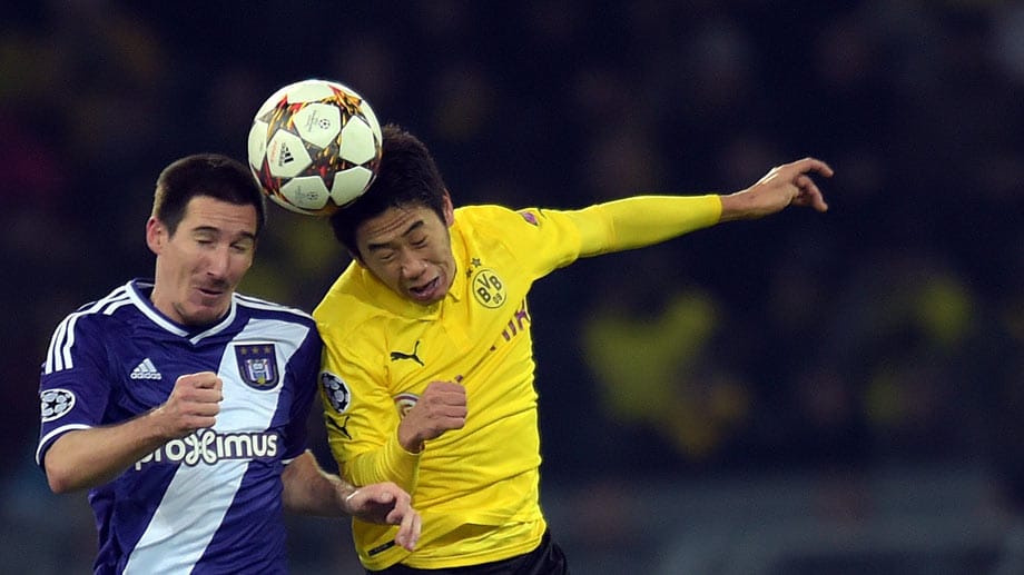 Augen zu und durch: Dortmunds Shinji Kagawa springt zum Kopfballduell mit Sacha Kljestan von Anderlecht.