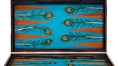 Das Backgammon-Set aus afrikanischem Zebrano-Holz, mit vergoldeten Verschlüssen und handbemaltem Innenleben mit Pfauenfedern (für 4295 Euro über Ahalife) wird in der Londoner Manufaktur von Alexandra Llewellyn handgefertigt.