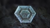 Auf dieser Aufnahme ist sehr gut die sechseckige Grundstruktur der Eiskristalle zu erkennen. Die räumliche Anordnung der Atome im Wassermolekül lässt nur ein hexagonales Kristallgitter zu.