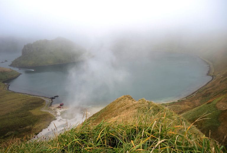 Auf der Insel Yankicha sprudeln heiße Quellen aus dem Boden. Vom Rand eines alten Vulkankraters sieht man die Ausmaße des Kratersees.