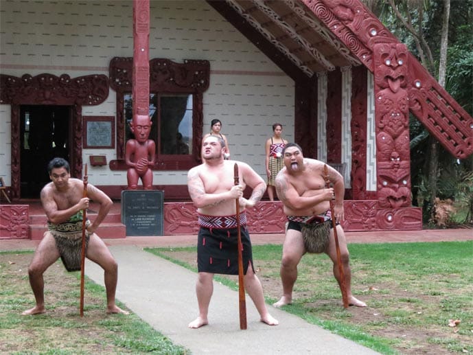 Das Versammlungshaus Te Whare Rununga ist kunstvoll verziert. Davor führen die Maori das Haka-Spektakel auf.