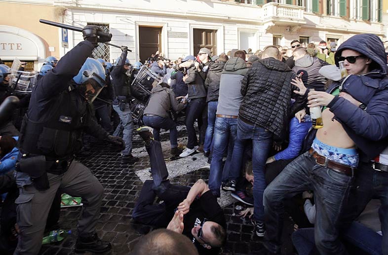 Die Polizei geht mit aller Gewalt gegen die Feyenoord-Anhänger vor, die zuvor den Brunnen Fontana della Barcaccia beschädigt hatten.