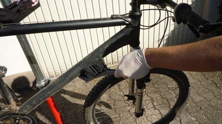 Fahrrad putzen: Laufräder mit Handfeger abbürsten.