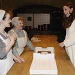 In der Film-Küche überraschen die Darstellerinnen von Köchin Mrs. Patmore (Lesley Nicol) und Küchenhilfe Daisy (Sophie McShera) die Herzogin mit einem Schokokuchen.