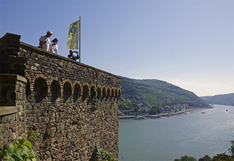 Das Rheintal hat sich längst als Wanderparadies etabliert. Hier genießen Wanderer auf der Rhein-Burg bei Rheinstein die Aussicht.
