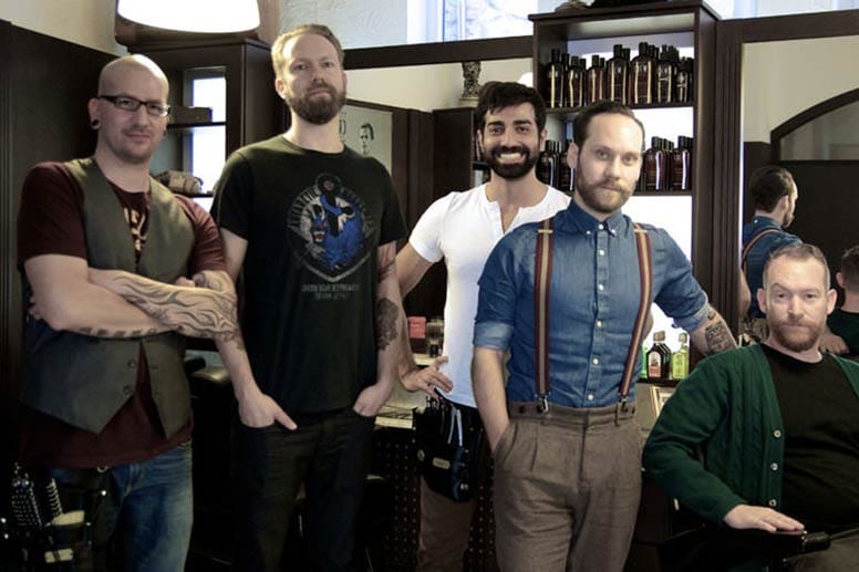 Thorsten Staudt (ganz links) und seine Crew von Jimmy Ray’s Barbershop in Nürnberg leben den typischen Lifestyle der angesagten Barbershops: coole Bärte und Tattoos, dazu feine Klamotten von der Fliege bis zu Hosenträgern.