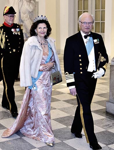 Eher gewöhnungsbedürftig war die Kleiderwahl von Königin Silvia von Schweden, die an der Seite eines offenbar schlecht gelaunten Königs Carl XVI. Gustaf kam. Zur rosa gemusterten Robe trug Silvia ein Pelzjäckchen, goldene Schuhe, eine goldene Tasche und Schmuck, der in Blau und Silber gehalten war.