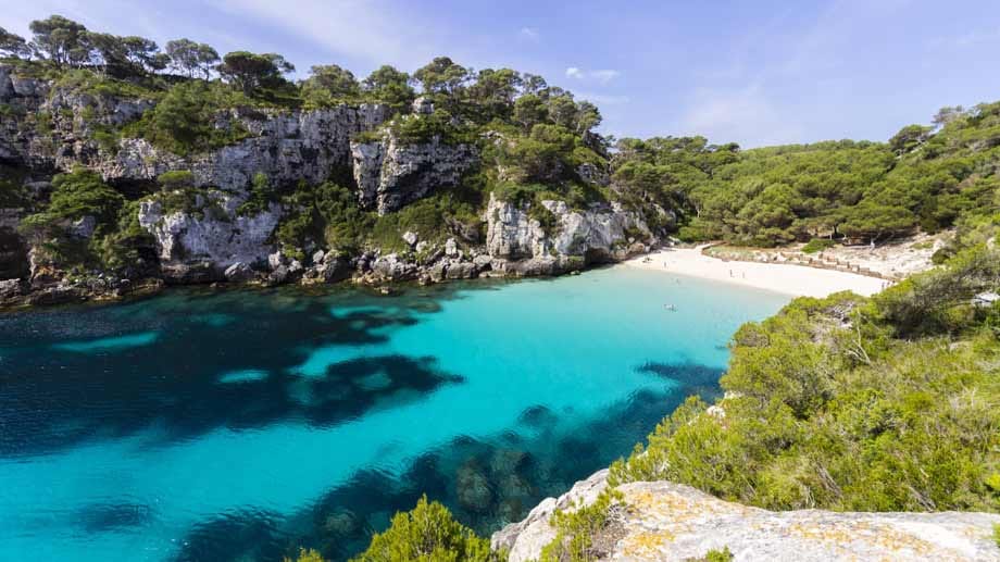 Eine der beliebtesten Badebuchten Menorcas ist die Cala Macarella. Doch der Weg zum Glück führt wohl oder übel über eine Dreiviertelstunde wandern durch Pinienwälder. Die Felsbucht mit dem weißen Sand liegt an der Südküste der Insel, der Wanderweg zu ihr beginnt in dem kleinen Ort Cala Santa Galdana, an der Treppe zur Bar "Mirador".