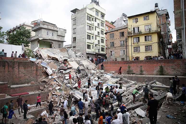 Das schwere Erdbeben, das sich um die Mittagszeit ereignet, lässt in Kathmandu zahlreiche Häuser einstürzen.