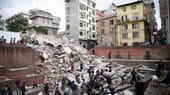 Das schwere Erdbeben, das sich um die Mittagszeit ereignet, lässt in Kathmandu zahlreiche Häuser einstürzen.