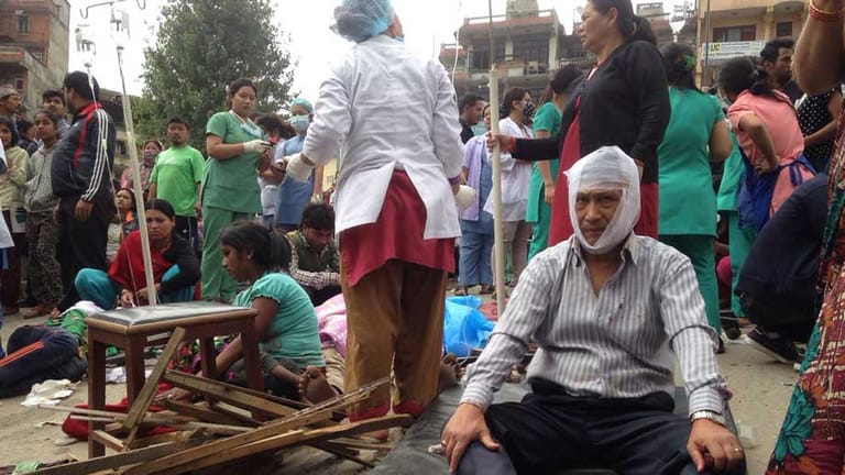 Angestellte des Krankenhauses von Kathmandu versorgen Verletzte so gut wie möglich außerhalb der Klinik.