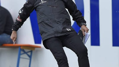 In der Partie gegen Heidenheim versucht Pauli-Coach Ewald Lienen an der Seitenlinie einen Ball zu stoppen.