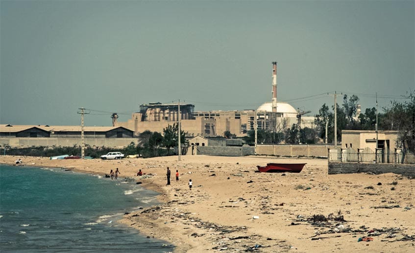 Zwischen Meiler und Meer: Badende Menschen am Strand vor dem Atomkraftwerk Bushehr im Iran.
