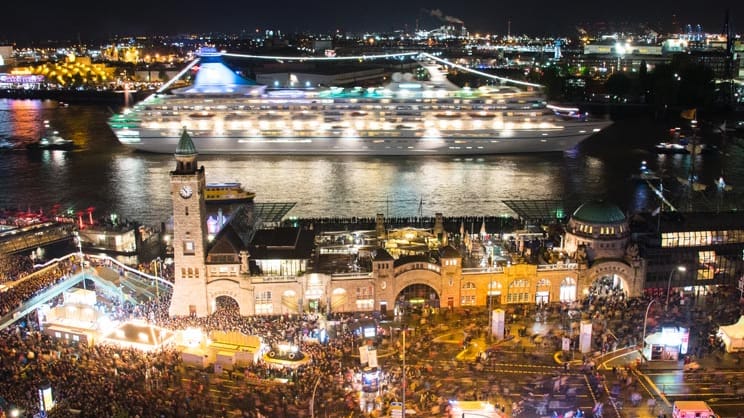 Die hell erleuchtete "Artania" fährt am Samstag Abend vor den Landungsbrücken vorbei.