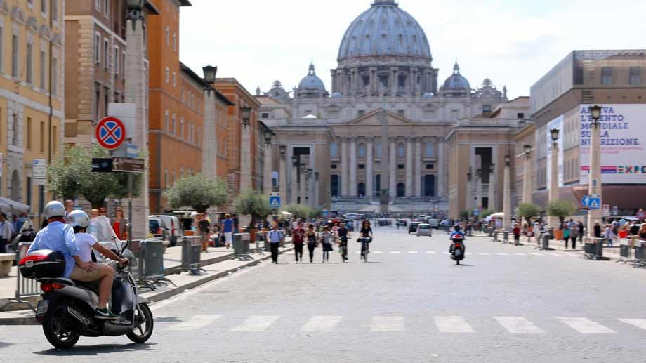 Diese Rollerfahrer haben einen wunderschönen Blick auf den Petersdom.