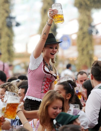 Eine Besucherin in Tracht feiert 2014 auf dem Oktoberfest in München in einem der Festzelte. Wer in einer Gruppe ein Festzelt besuchen möchte, sollte vorab einen Sitzplatz reservieren.