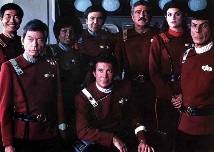 So sah die Star-Trek-Mannschaft im Kinofilm "Star Trek II - der Zorn des Khan aus" (1982): In der Mitte sitzt William Shatner als Captain James T. Kirk, direkt hinter ihm steht Walter Koenig, links danben ist Nichelle Nichols zu sehen.