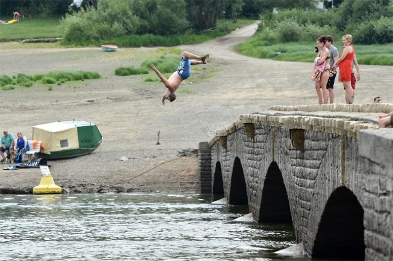 Die Besucher genießen das tolle Wetter im halbleeren See. So wird die Aseler Brücke gleichzeitig zum Sprungturm.