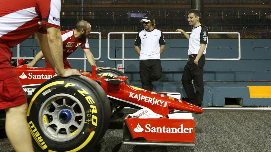 Ex-Ferrari-Pilot Fernando Alonso (2.v.re.) schaut seinen ehemaligen Kollegen bei der Arbeit zu.