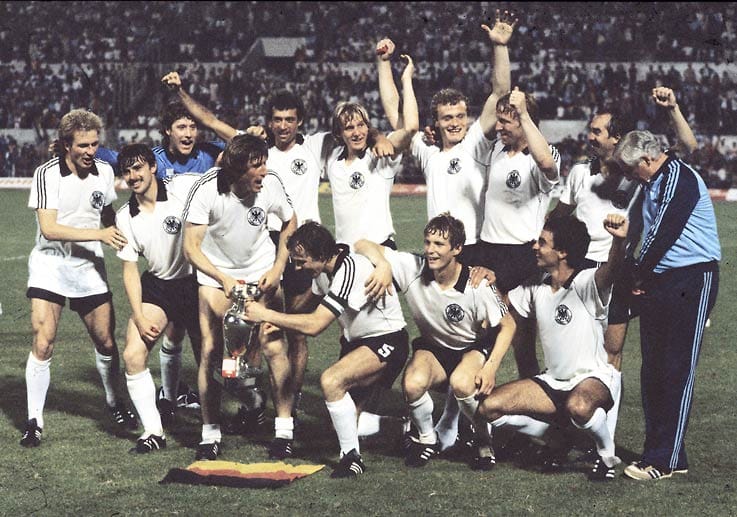 1980 gewinnt Rummenigge (li.) mit der deutschen Nationalmannschaft in Italien den Europameister-Titel und wird zum besten Spieler des Turniers gewählt. Ihm gelingt bei dem Turnier ein Tor, im Finale bereitet er mit einem Eckball den Siegtreffer zum 2:1 von Sturmpartner Horst Hrubesch gegen Belgien vor.