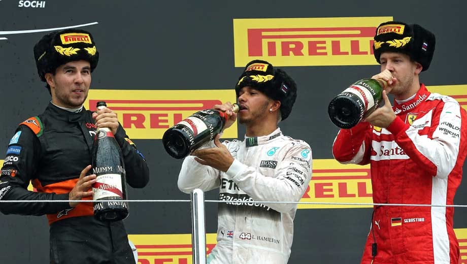 Mit landestypischen Bärenfellmützen feiern Sergio Perez, Lewis Hamilton und Sebastian Vettel ihre Podestplatzierungen.